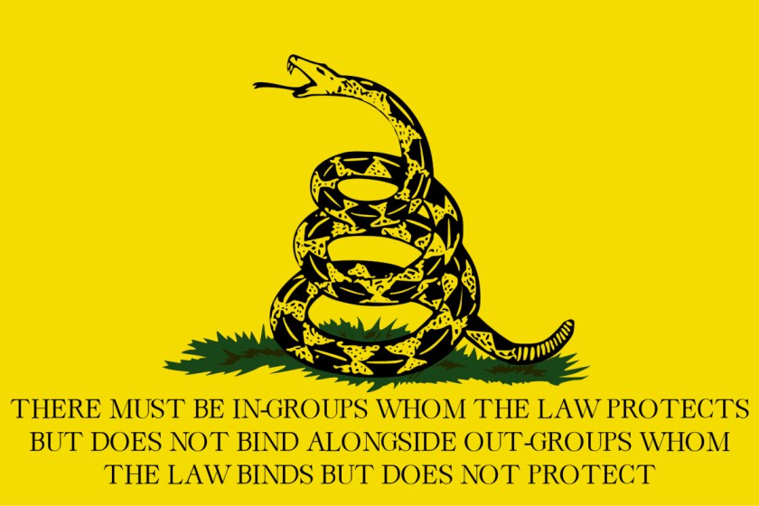 The Gadsen 'DONT TREAD ON ME' flag; the text has been replaced with 'THERE MUST BE IN-GROUPS WHOM THE LAW PROTECTS BUT DOES NOT BIND ALONGSIDE OUT-GROUPS WHOM THE LAW BINDS BUT DOES NOT PROTECT.'